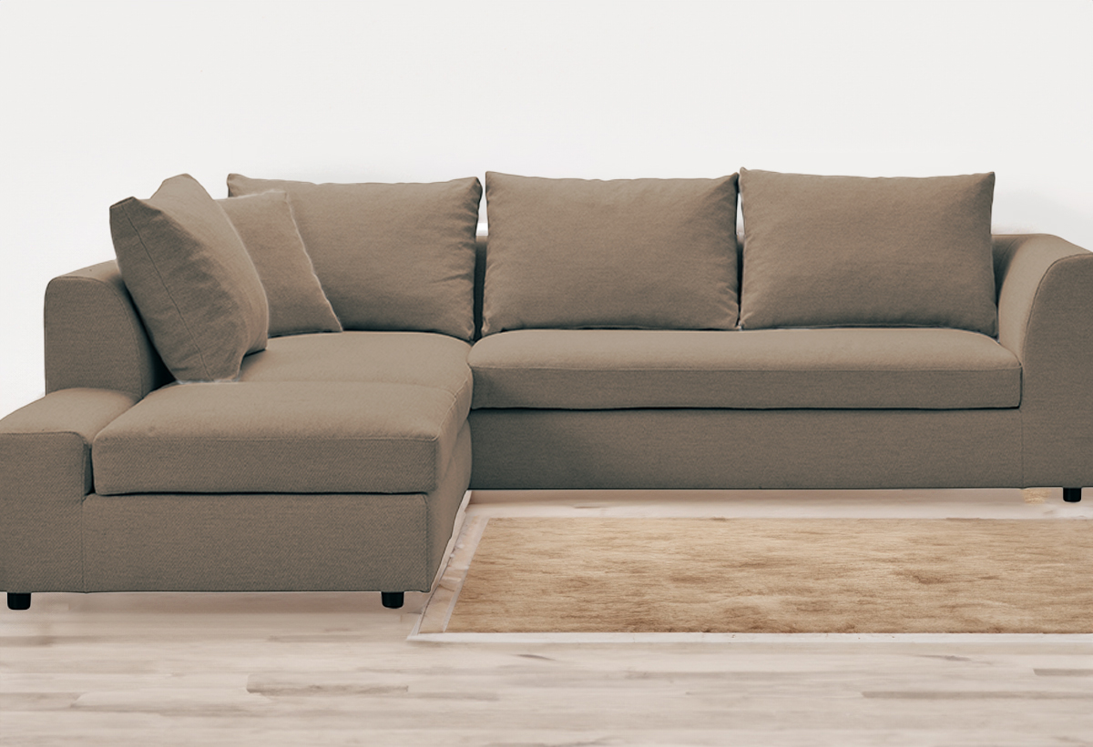 Απεικονίζεται ο καναπές τοποθετημένος σε ένα σαλόνι με ένα καφέ χαλί
